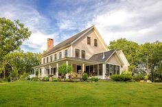 a large white house sitting on top of a lush green field