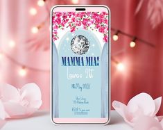 a phone with the name mamma mia on it next to pink flowers and lights