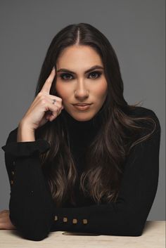 a woman sitting at a table with her hand on her head and looking off to the side