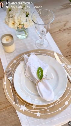 the table is set with white and gold plates, napkins, and silverware