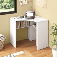 a computer desk with a laptop on top of it next to a potted plant