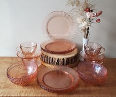 a table topped with pink glass dishes and plates