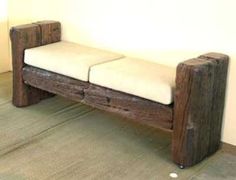 a wooden bench sitting on top of a floor next to a white wall in a room