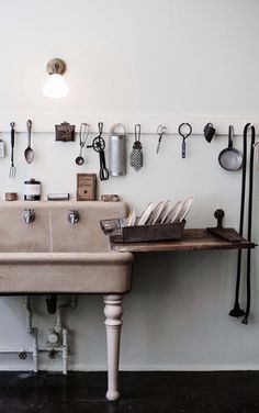 a kitchen sink with utensils hanging on the wall