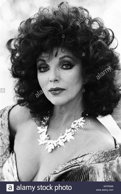 an old black and white photo of a woman with long curly hair wearing a dress