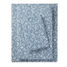 the blue and white floral print sheet set is folded on top of a pillow case