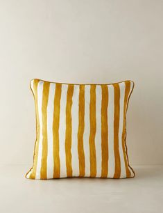 a yellow and white striped pillow sitting on top of a table