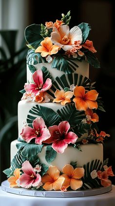 a three tiered cake decorated with flowers and leaves