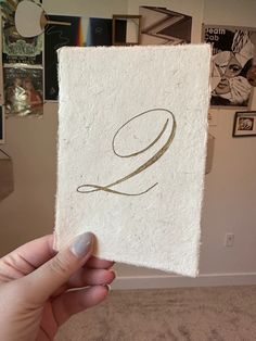 someone holding up a piece of paper with the letter q on it