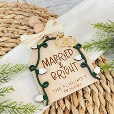 a wooden sign that says married and bright with two wedding rings hanging from the front