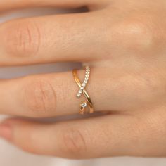 a woman's hand with a gold ring and diamond band on her left hand