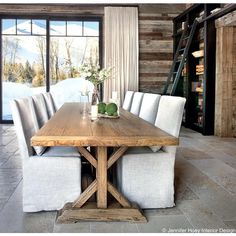 a wooden table with white chairs around it