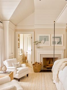 a bedroom with white furniture and a fireplace