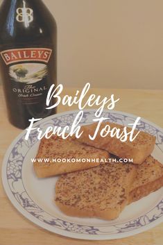 two pieces of bread on a plate with a bottle of bailey's french toast in the background