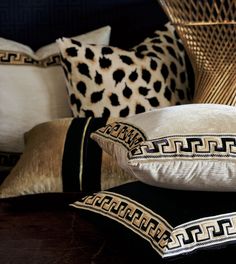 decorative pillows are stacked on top of each other in front of a wicker basket