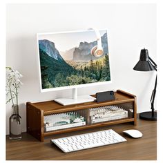 a computer monitor sitting on top of a wooden desk next to a keyboard and mouse