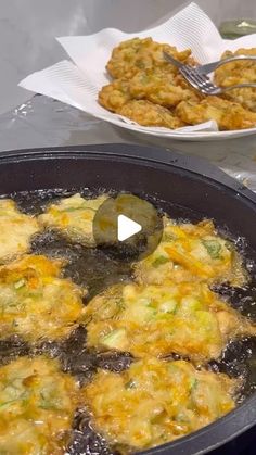 an omelet is being cooked in a pan with other food on the table