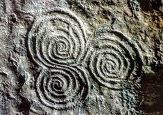 three circles carved into the side of a rock with swirls in it's center