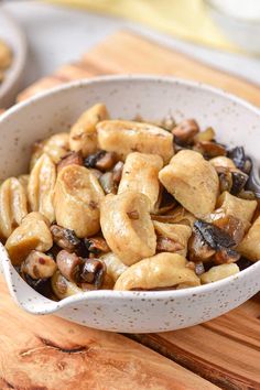 a white bowl filled with cashews and mushrooms