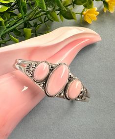 Handcrafted sterling silver Southwestern cuff bracelet with natural pink conch shell stones. The bracelet's inner circumference measures 7" which includes the 1-1/4" opening. It is adjustable. It can be squeezed in to fit a 6" wrist or it can be extended out to fit up to a 8" wrist. The width at the top is 7/8". The silver is 925 sterling silver and stamped sterling. You will receive the exact item in a gift box. Thanks for looking and check out more items in my Etsy shop for more great items an Conch Shell, Conch, Cuff Bracelet, Cuff Bracelets, Jewelry Bracelets, Shells, Gift Box, Accessory Gift, 925 Sterling Silver