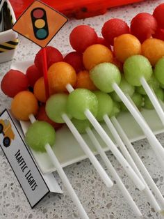 fruit skewers are lined up on a plate