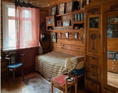 a bedroom with wood paneled walls and flooring is shown in this image, there are bookshelves on either side of the bed