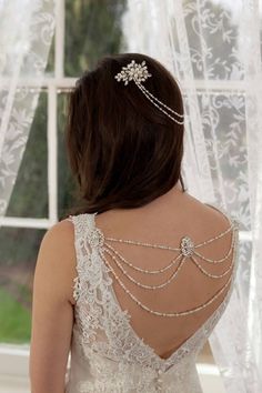 the back of a woman's wedding dress with pearls on it