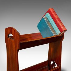 a wooden shelf with books on top of it and a book holder in the middle