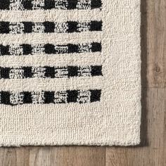 a black and white rug on top of a wooden floor