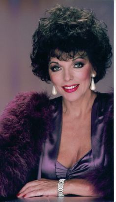 an old photo of a woman wearing a purple dress and fur stole around her shoulders