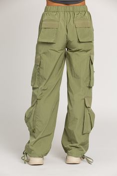 NEW Limited Edition & custom designed Shiny Olive Green Parachute Pants! Not only did we spend months designing these amazing cargo style pants, but we PERFECTED them in the process! These pants are insanely versatile due to their lightweight material and trendy style. They feature adjustable ankle cuffs that you can leave wide or tie up for a jogger look. The elastic waist-band allows for a comfortable fit and the multiple pockets provide great functionality. These pants easily can be worn for Green Parachute Pants, Olive Green Pants, Crop Bra, Tennis Skirts, Crop Top Bra, Cargo Style, Athletic Top, Green Pants, Pink Pants