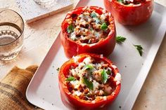 three stuffed red peppers on a plate with some garnishes in the middle