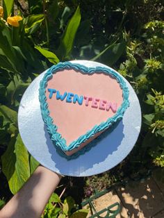 a heart shaped cake with the word twenten written on it in blue frosting