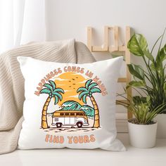 a white pillow sitting on top of a chair next to a potted plant