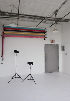 an empty room with two light stands in front of the door