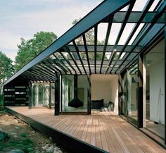 a wooden deck with glass walls and sliding doors