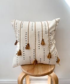 a white pillow sitting on top of a wooden chair