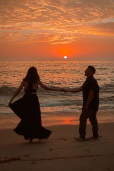 young couple dancing with the sunset to la vie en rose. girl is wearing black dress and boy is in khakis and a dark button up. The sun is setting behind them, spreading a bright orange and pink hue across the sky and into a set of clouds at the very top of the photo.the photo is taken at a beach in La Jolla San Diego California. Couples On Beach Sunset, Sun Set Couple Photos, Sunset Couple Photography Beach Photo Ideas, Couple Beach Sunset, Goa Couple, Golden Hour Beach Engagement Photos, Sunset Photoshoot Ideas Golden Hour, Proposal On Beach