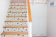 the stairs are painted with black and white designs on them, along with an area rug that matches the carpet