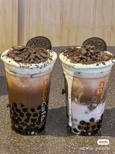 two drinks with oreo cookies on top and milkshake in the middle, sitting next to each other