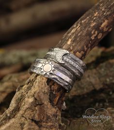 two wedding rings sitting on top of a tree branch