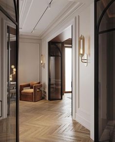 an empty room with wooden flooring and two brown chairs in it's center