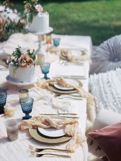 the table is set with plates, silverware and napkins for an elegant dinner