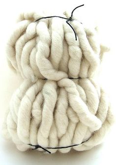 two balls of white wool sitting on top of each other