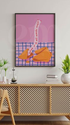 a painting hanging on the wall next to a wooden sideboard with two chairs and a potted plant