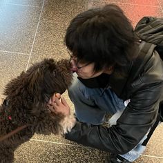 a woman kissing her dog on the nose