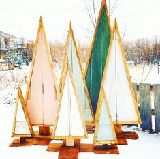 three wooden sailboats sitting on top of snow covered ground