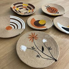 woven baskets with designs on them sitting on a wooden floor