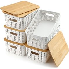 white storage baskets with bamboo lids and cutting boards on the bottom are stacked next to each other