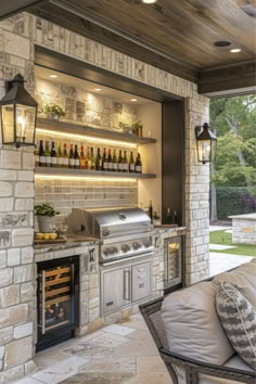 an outdoor kitchen with stone walls and built - in bbq, oven, seating area and grill